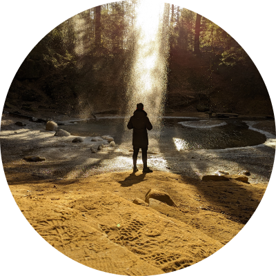 person standing under a waterfall